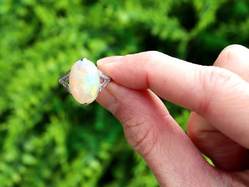 fig 1. An Art Deco 18ct white gold ring featuring a central oval cabochon white opal flanked by geometric diamond-set shoulders.
