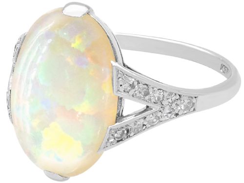 fig 5. An Art Deco 18ct white gold ring featuring a central oval cabochon white opal flanked by geometric diamond-set shoulders.