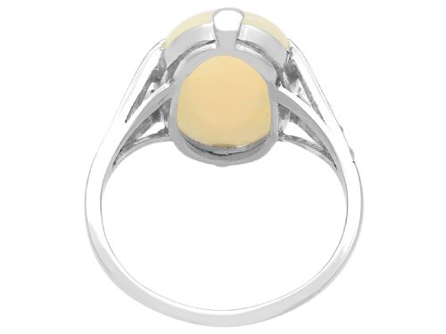 fig 6. An Art Deco 18ct white gold ring featuring a central oval cabochon white opal flanked by geometric diamond-set shoulders.
