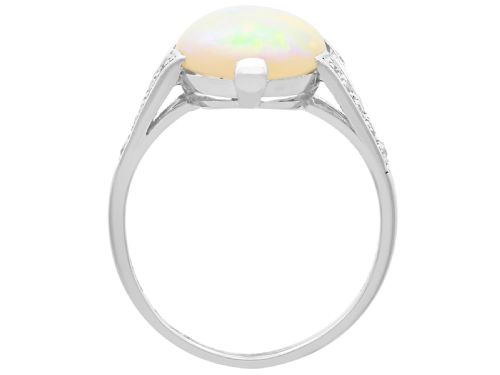 fig 7. An Art Deco 18ct white gold ring featuring a central oval cabochon white opal flanked by geometric diamond-set shoulders.