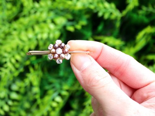 fig 1. An antique 15ct yellow gold bar brooch featuring a central floral cluster set with dark pearls and old-cut diamonds.