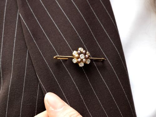 fig 4. An antique 15ct yellow gold bar brooch featuring a central floral cluster set with dark pearls and old-cut diamonds.