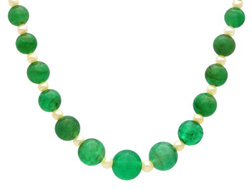 fig 1. An antique single strand necklace displaying alternating green emerald beads and cream pearls connected to a geometric platinum and diamond clasp.
