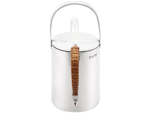 fig 3. An Edwardian sterling silver watering can featuring a cylindrical body, straight spout, overhead loop handle, woven cane side handle, and an engraved central monogram.