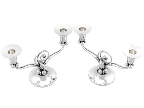 fig 4. A pair of sterling silver two-light Arts and Crafts style candelabra featuring scrolled arms, beaded motifs, and flared sconces on circular bases.