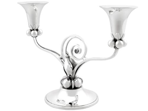 fig 6. A pair of sterling silver two-light Arts and Crafts style candelabra featuring scrolled arms, beaded motifs, and flared sconces on circular bases.