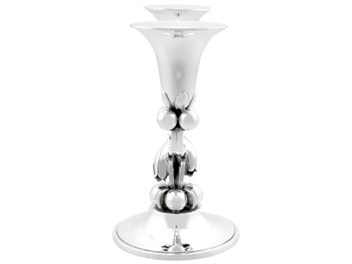 fig 7. A pair of sterling silver two-light Arts and Crafts style candelabra featuring scrolled arms, beaded motifs, and flared sconces on circular bases.