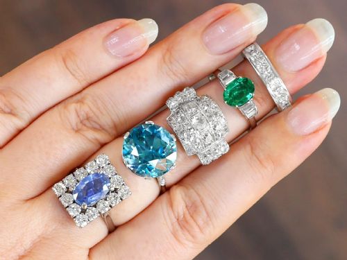 fig 4. An Art Deco platinum dress ring with a central oval green emerald set in claws and flanked by step-cut baguette diamonds on each shoulder.