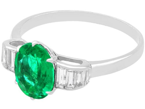 fig 5. An Art Deco platinum dress ring with a central oval green emerald set in claws and flanked by step-cut baguette diamonds on each shoulder.