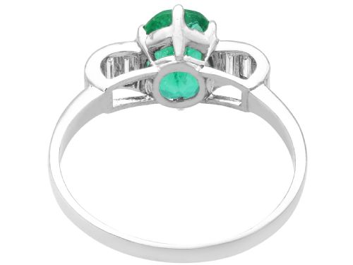 fig 6. An Art Deco platinum dress ring with a central oval green emerald set in claws and flanked by step-cut baguette diamonds on each shoulder.