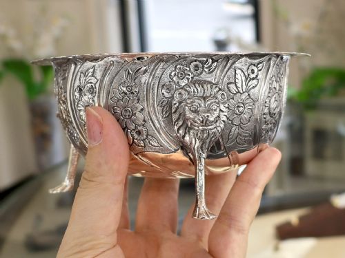 fig 4. A mid-18th-century Irish sterling silver sugar bowl featuring repousse floral decoration, a scalloped rim, and three lion mask legs.