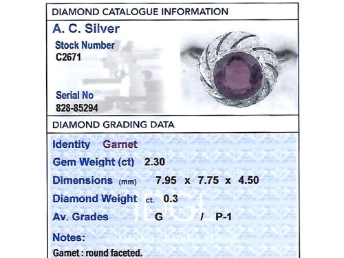 fig 6. An Art Deco platinum dress ring featuring a central round red garnet surrounded by a swirling spiral bezel set with small diamonds.