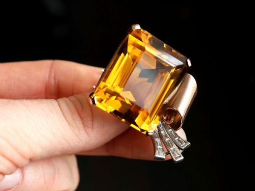 fig 2. A large emerald-cut amber citrine stone set in a 14ct yellow gold brooch mounting accented with baguette diamonds.