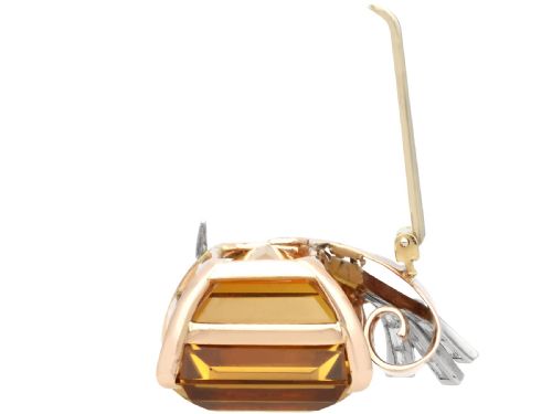 fig 7. A large emerald-cut amber citrine stone set in a 14ct yellow gold brooch mounting accented with baguette diamonds.