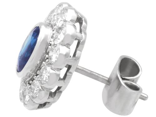 fig 8. Pair of 1930s 18ct white gold cluster earrings featuring oval blue sapphire centerpieces framed by halos of round diamonds.
