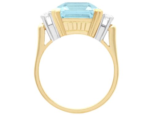 fig 9. A 14ct yellow gold dress ring featuring a large emerald-cut light blue aquamarine central gemstone flanked by six round diamonds.