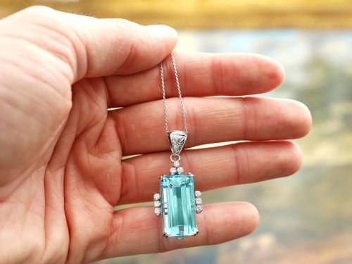 fig 4. A vintage 18ct white gold pendant featuring a large emerald-cut light blue aquamarine framed by accent diamonds, suspended from an engraved bail.