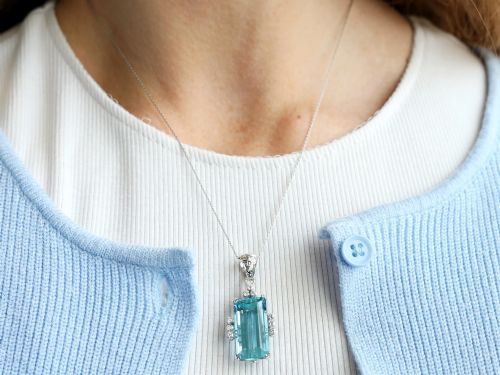 fig 5. A vintage 18ct white gold pendant featuring a large emerald-cut light blue aquamarine framed by accent diamonds, suspended from an engraved bail.
