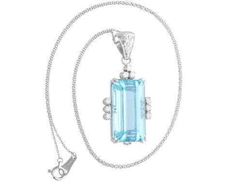 fig 7. A vintage 18ct white gold pendant featuring a large emerald-cut light blue aquamarine framed by accent diamonds, suspended from an engraved bail.