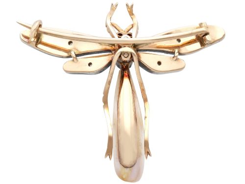 fig 9. An antique late Victorian dragonfly brooch crafted in yellow gold with yellow enamel wings, garnet eyes, rose-cut diamond accents, and a elongated natural pearl abdomen.