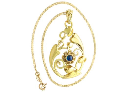 fig 5. An openwork Art Nouveau 14ct yellow gold pendant featuring botanical leaf motifs surrounding a central bezel-set blue sapphire.