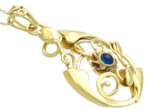 fig 6. An openwork Art Nouveau 14ct yellow gold pendant featuring botanical leaf motifs surrounding a central bezel-set blue sapphire.