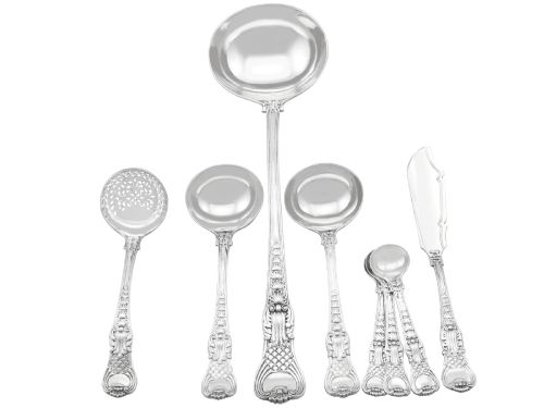 fig 1. A collection of ornate sterling silver cutlery pieces featuring intricately embossed handles and polished bowls, including ladles, forks, knives, and spoons.