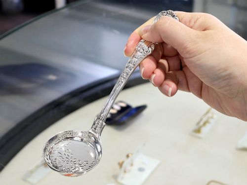 fig 2. A collection of ornate sterling silver cutlery pieces featuring intricately embossed handles and polished bowls, including ladles, forks, knives, and spoons.