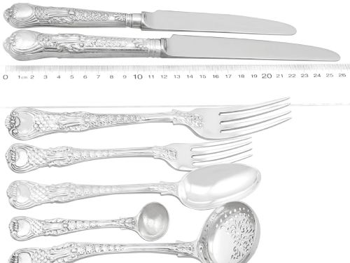 fig 6. A collection of ornate sterling silver cutlery pieces featuring intricately embossed handles and polished bowls, including ladles, forks, knives, and spoons.