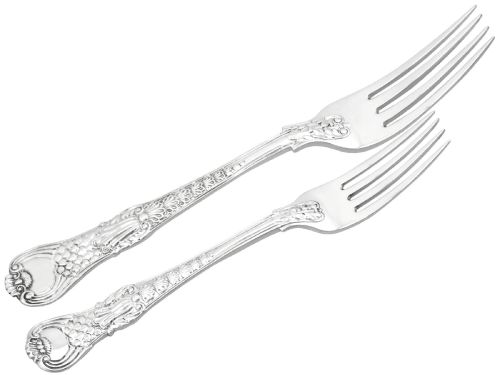 fig 7. A collection of ornate sterling silver cutlery pieces featuring intricately embossed handles and polished bowls, including ladles, forks, knives, and spoons.