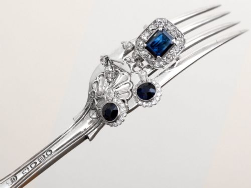 fig 6. An Art Deco platinum cluster ring featuring a central rectangular blue sapphire surrounded by twelve old-cut diamonds with millegrain edges.