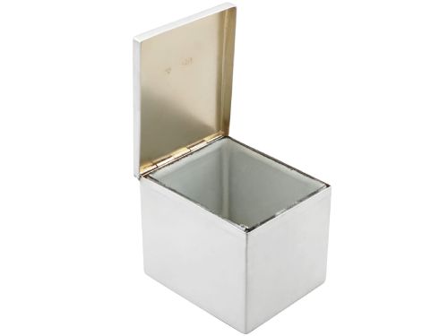 fig 4. A rectangular Victorian sterling silver tea caddy featuring an engraved crest, top folding handle, and visible side hallmarks.