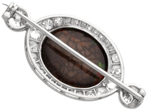 fig 6. An Edwardian platinum brooch featuring an oval cabochon boulder opal surrounded by a halo of diamonds and two outer accent diamonds.