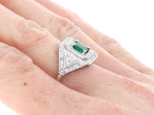 fig 8. An Art Deco platinum ring featuring a central square green emerald surrounded by geometric concentric halos of brilliant-cut diamonds.