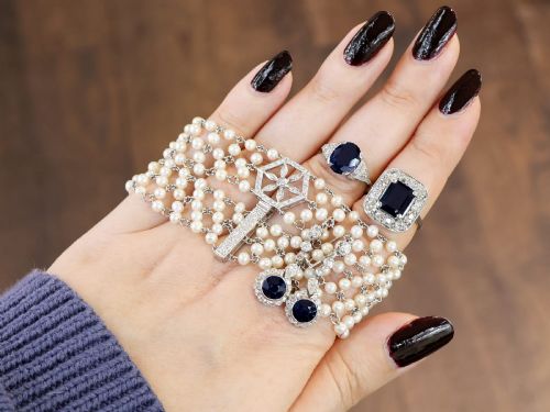fig 1. An Art Deco platinum ring featuring a centrally set oval blue sapphire flanked by diamond-set geometric shoulders.