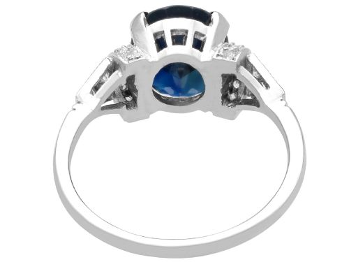 fig 4. An Art Deco platinum ring featuring a centrally set oval blue sapphire flanked by diamond-set geometric shoulders.