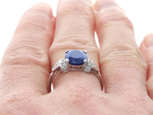 fig 9. An Art Deco platinum ring featuring a centrally set oval blue sapphire flanked by diamond-set geometric shoulders.