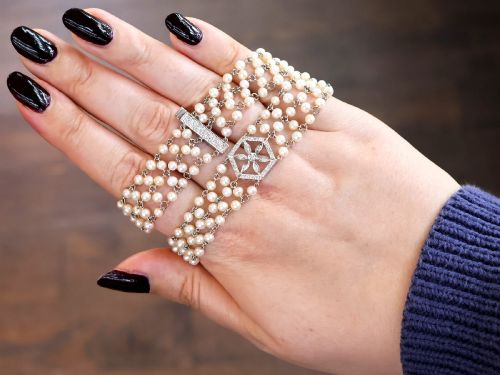 fig 2. A multi-strand white pearl choker necklace joined at the front by an 18ct white gold hexagonal plaque set with small diamonds.