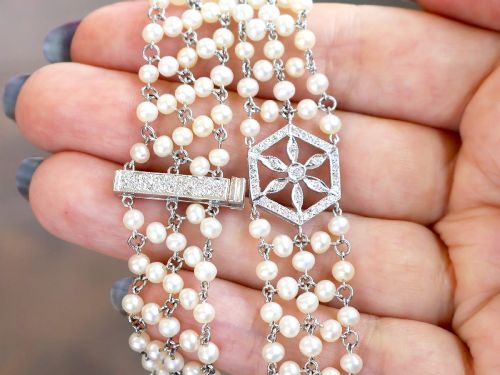 fig 3. A multi-strand white pearl choker necklace joined at the front by an 18ct white gold hexagonal plaque set with small diamonds.