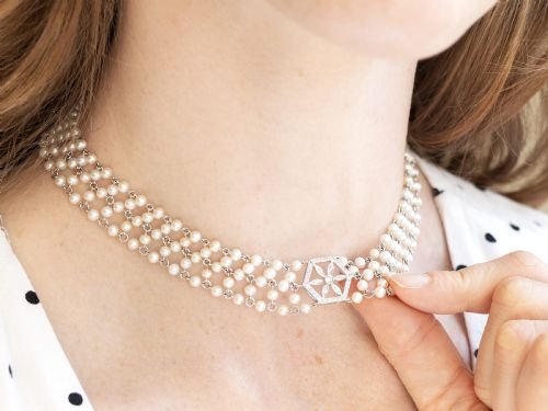 fig 4. A multi-strand white pearl choker necklace joined at the front by an 18ct white gold hexagonal plaque set with small diamonds.