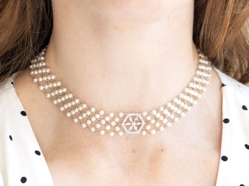 fig 5. A multi-strand white pearl choker necklace joined at the front by an 18ct white gold hexagonal plaque set with small diamonds.