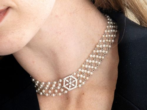 fig 6. A multi-strand white pearl choker necklace joined at the front by an 18ct white gold hexagonal plaque set with small diamonds.