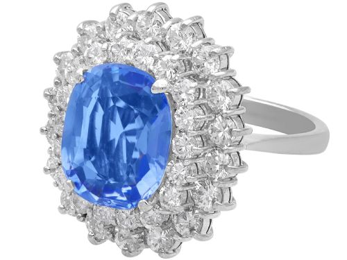 fig 5. A vintage 14ct white gold cluster ring featuring a centrally mounted cushion-cut blue Ceylon sapphire surrounded by a double halo of round brilliant diamonds.