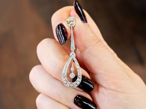 fig 2. A pair of Art Deco platinum drop earrings featuring openwork teardrop frames set with diamonds and geometric articulated tops.