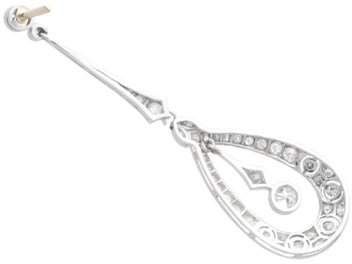 fig 5. A pair of Art Deco platinum drop earrings featuring openwork teardrop frames set with diamonds and geometric articulated tops.