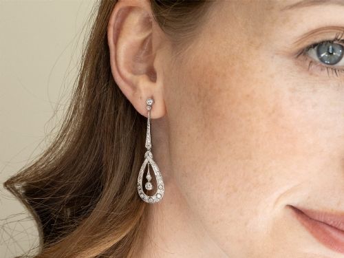 fig 7. A pair of Art Deco platinum drop earrings featuring openwork teardrop frames set with diamonds and geometric articulated tops.