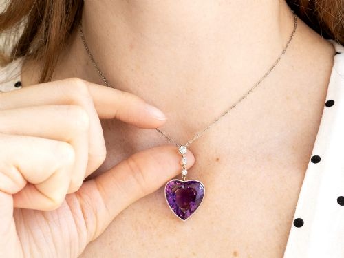 fig 5. An antique heart-cut purple amethyst pendant framed with a millegrain edge and suspended beneath three round diamond accents set in gold.