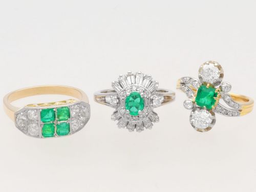 fig 5. An antique 18ct yellow gold twist ring set with a central green emerald, flanked by two old cut diamonds and diamond-set shoulders.