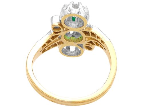 fig 7. An antique 18ct yellow gold twist ring set with a central green emerald, flanked by two old cut diamonds and diamond-set shoulders.