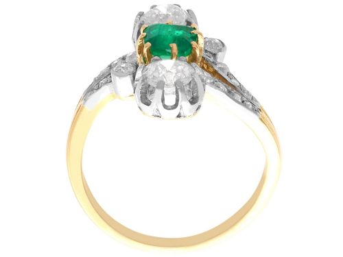 fig 8. An antique 18ct yellow gold twist ring set with a central green emerald, flanked by two old cut diamonds and diamond-set shoulders.